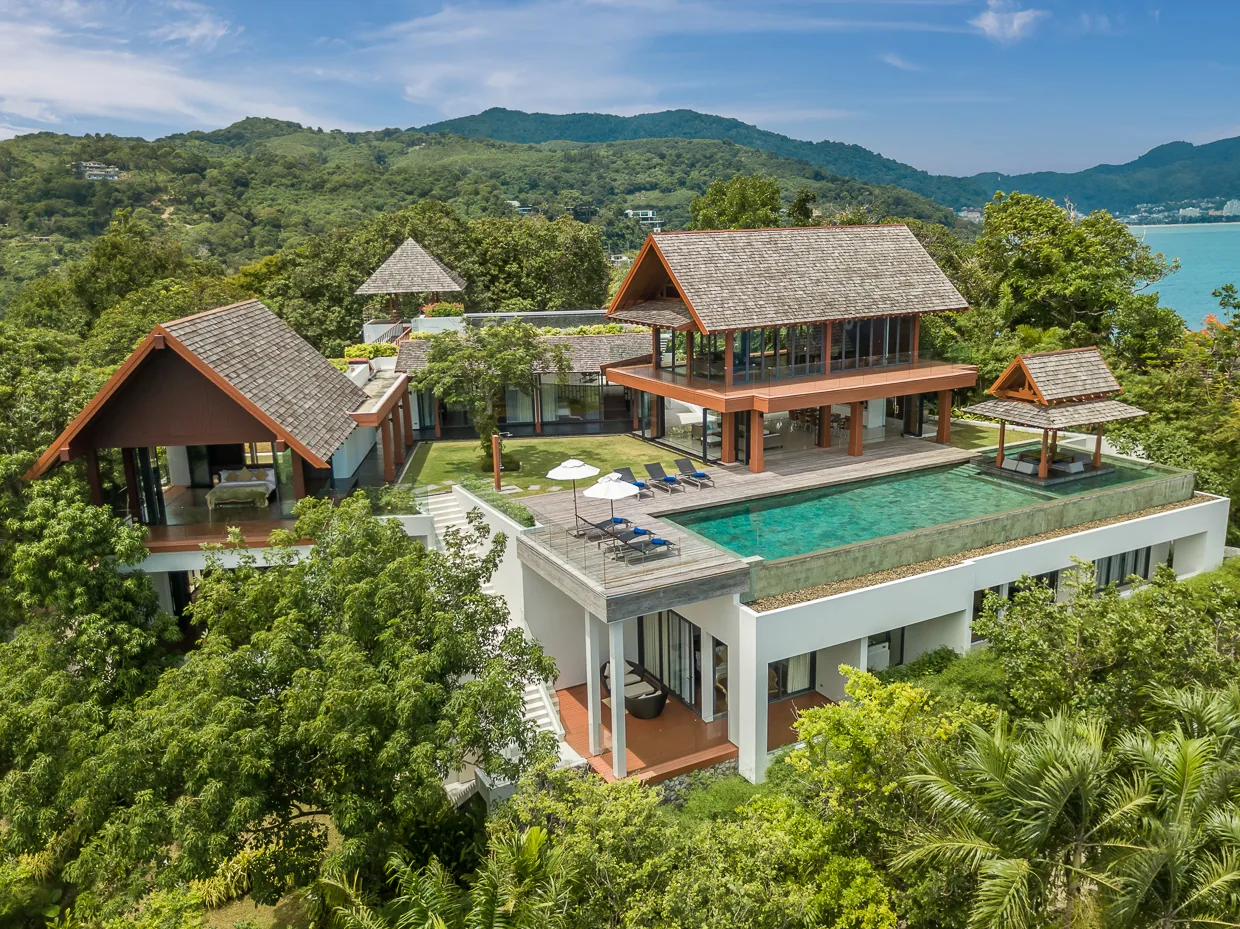 Villa Baan Santisuk from the air, its Thai gable roofs and pool above Kamala bay