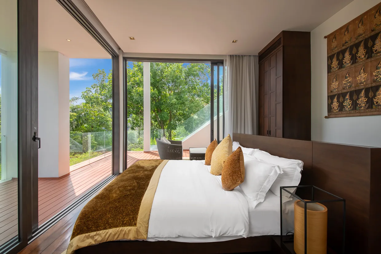 A bedroom with a saffron bed throw opening onto the deck