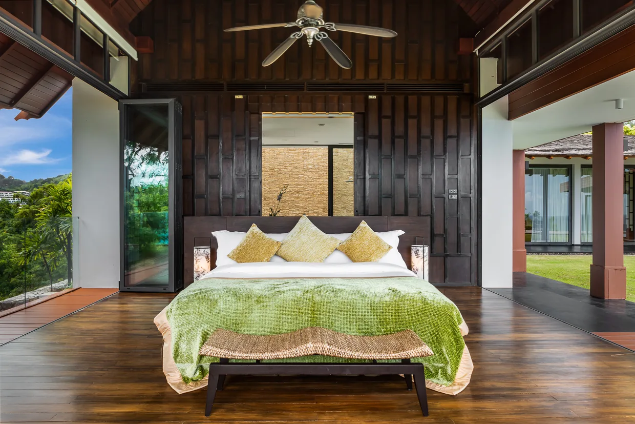 A bedroom panelled in dark teak, opening to the garden