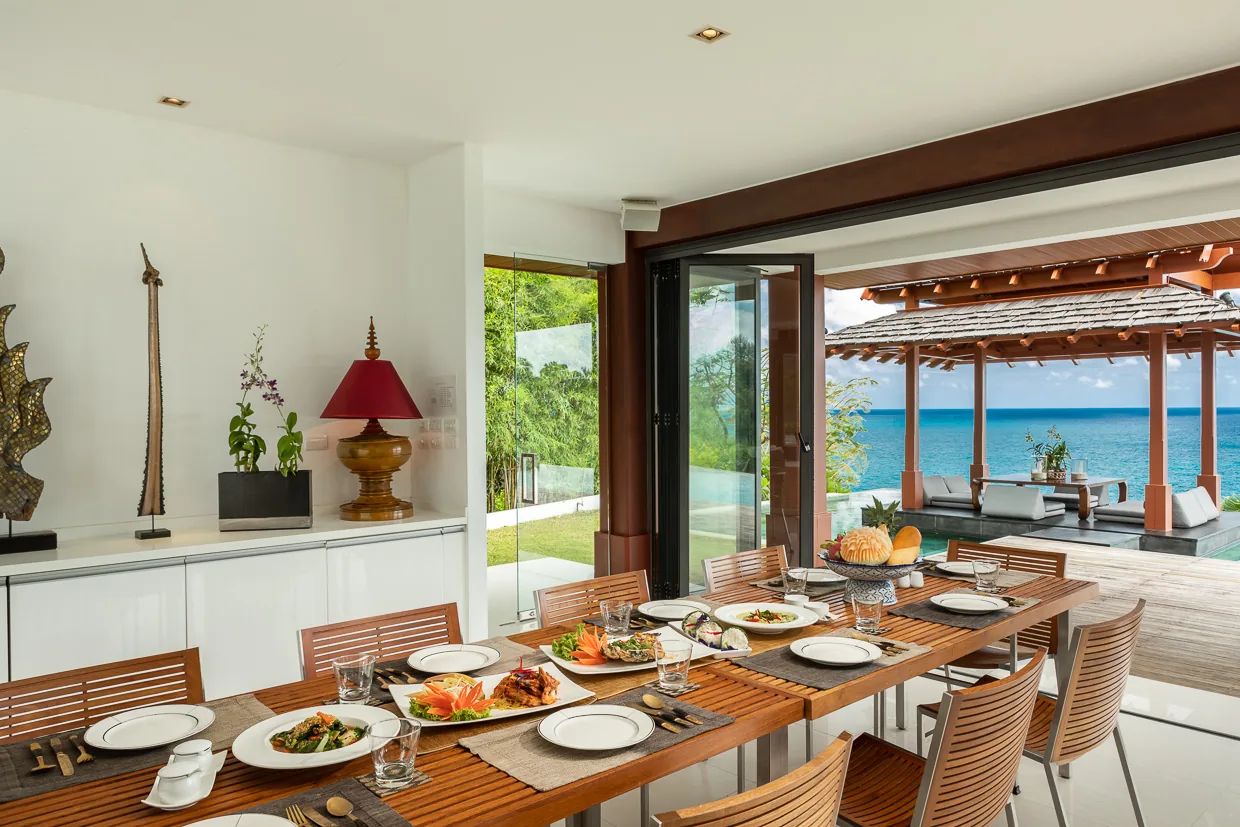 The indoor dining table laid for lunch, with the sala visible beyond