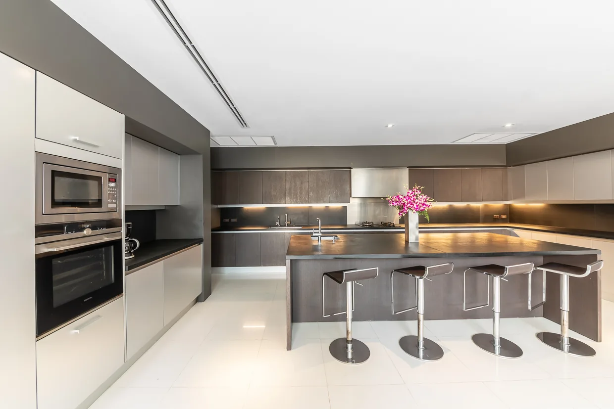 The modern kitchen with its island and bar stools