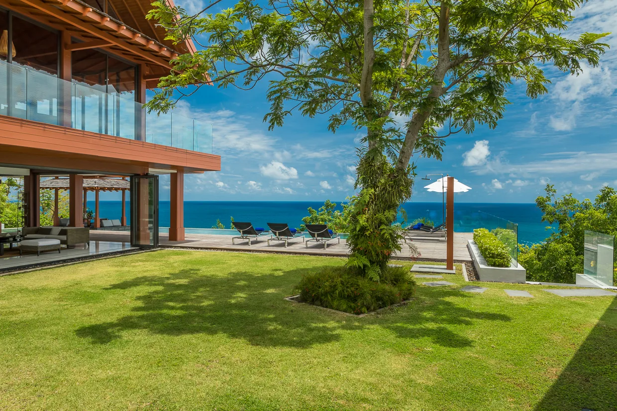 The villa lawn under its shade tree, looking out over the water