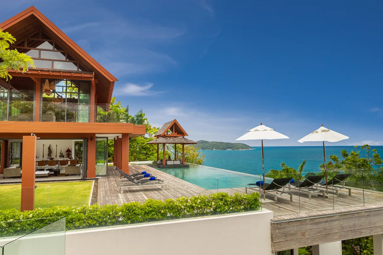 The vermilion timber columns of Villa Baan Santisuk beside the infinity pool