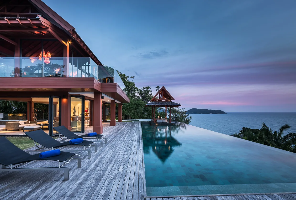 Villa Baan Santisuk lit at dusk, reflected in the pool
