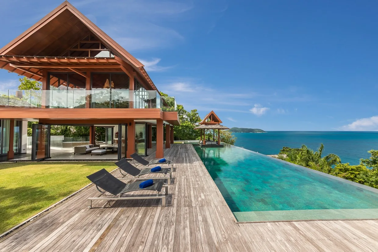Villa Baan Santisuk and its long infinity pool seen from the lawn