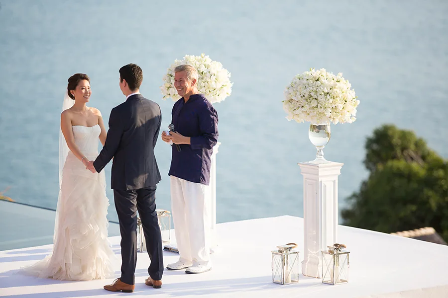 A wedding couple on the white aisle above the pool at Villa Baan Santisuk